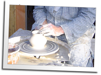 A craftsman turns a pot in the Blue Ox pottery shed